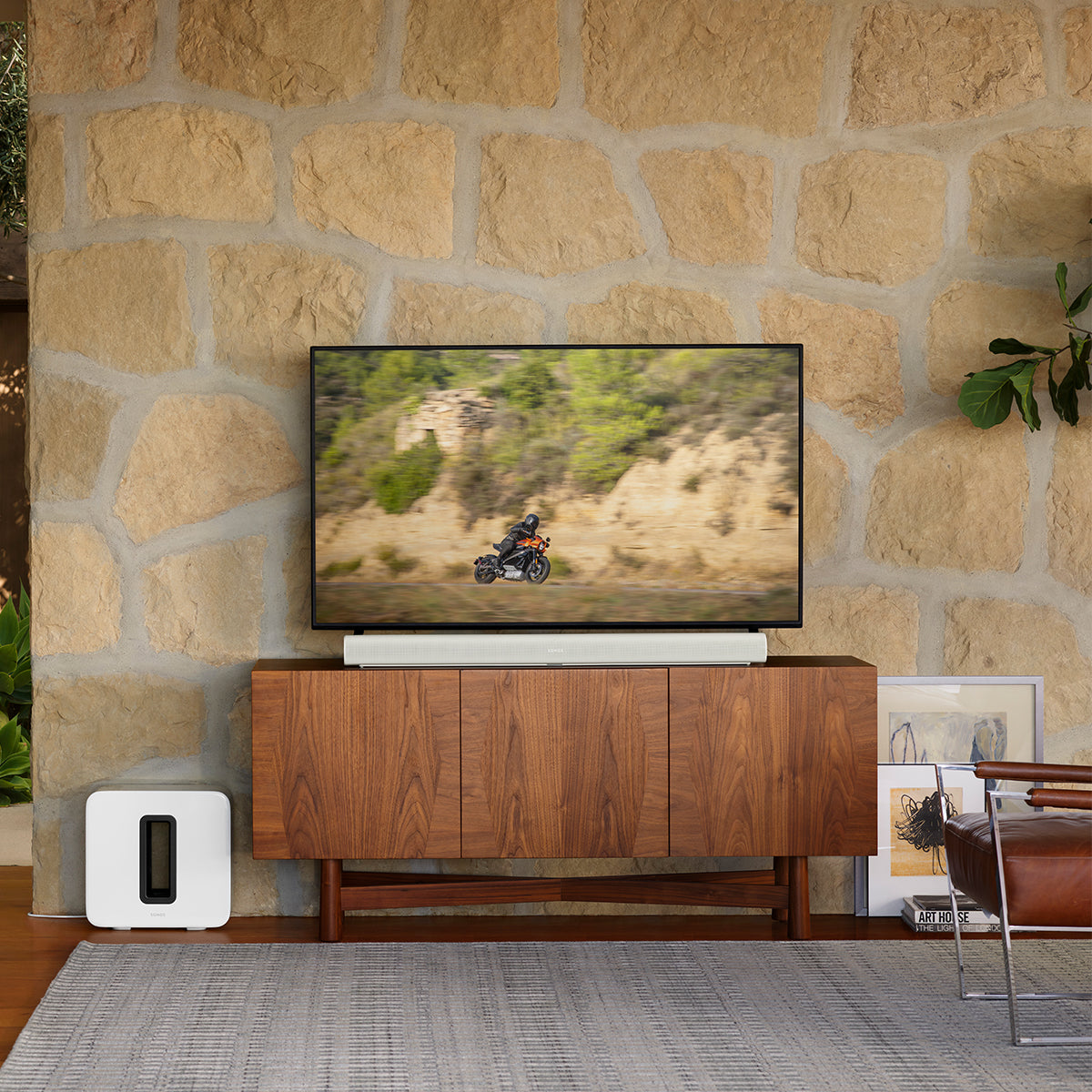 Sonos Arc Soundbar in white on a console table in front of a televsion